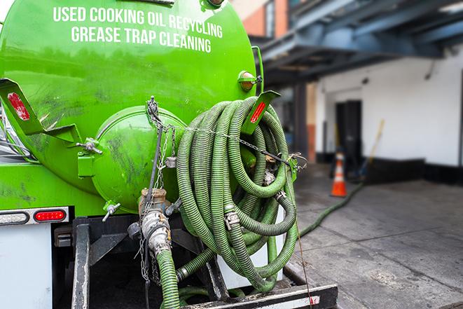 worker pumping grease trap at commercial kitchen in Charlottesville